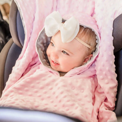 car seat poncho on baby girl sitting in car seat - pink
